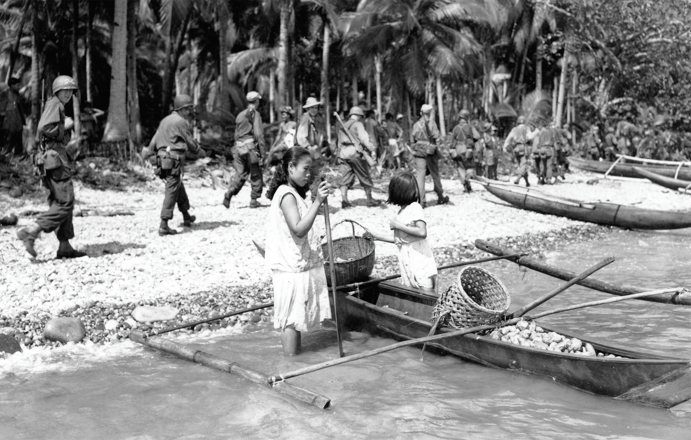 Soldiers of 24th Infantry Division march past Filipinas on beach at Leyte Island, Philippines, October 20, 1944 (National Archives and RecordsAdministration/U.S. Army Signal Corps)